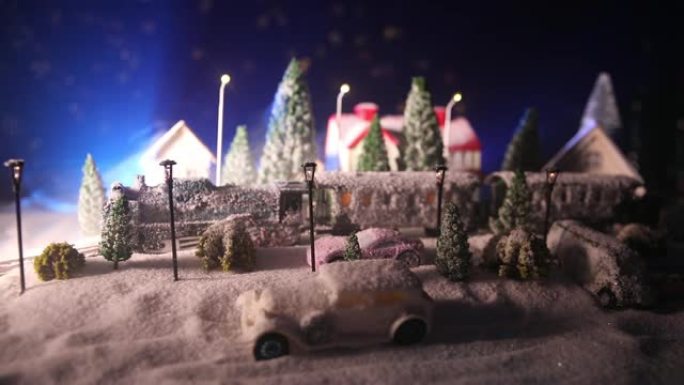 冬季场景的缩影，圣诞房屋，火车站，树木被雪覆盖。夜晚的场景。新年或圣诞节概念。选择性聚焦