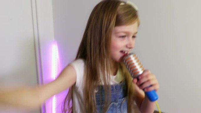 女孩正在玩具麦克风上唱歌