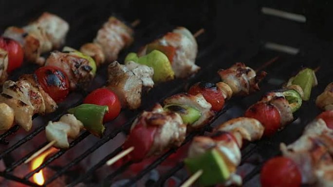 慢动作在烧烤架上的竹签上烹饪新鲜蔬菜和腌制的肉，并带有火和吸烟特写