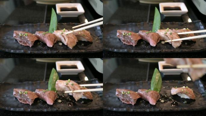 手拿筷子拿和牛寿司的前视图