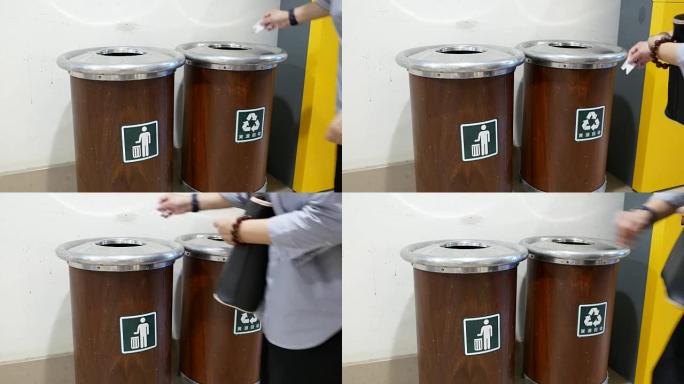 女人向购物中心内的垃圾桶扔垃圾的动议