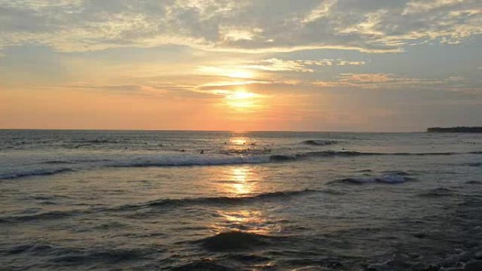 日落时冲浪者的热带海滩