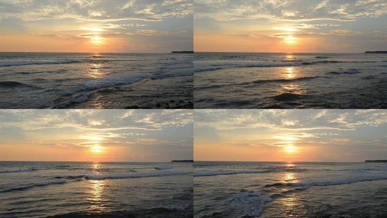 日落时冲浪者的热带海滩