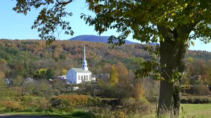 斯托的白色教堂被树木和落叶的小山所包围