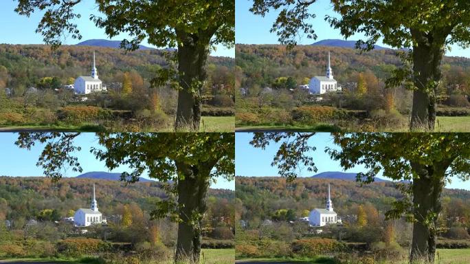 斯托的白色教堂被树木和落叶的小山所包围