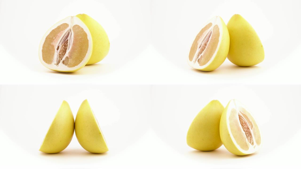 两半黄柚柑橘类水果在转盘上旋转。横截面切割。孤立在白色背景上。特写。宏观。