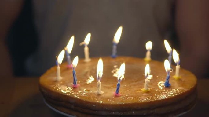 一个男人的背景上点燃蜡烛的节日蛋糕