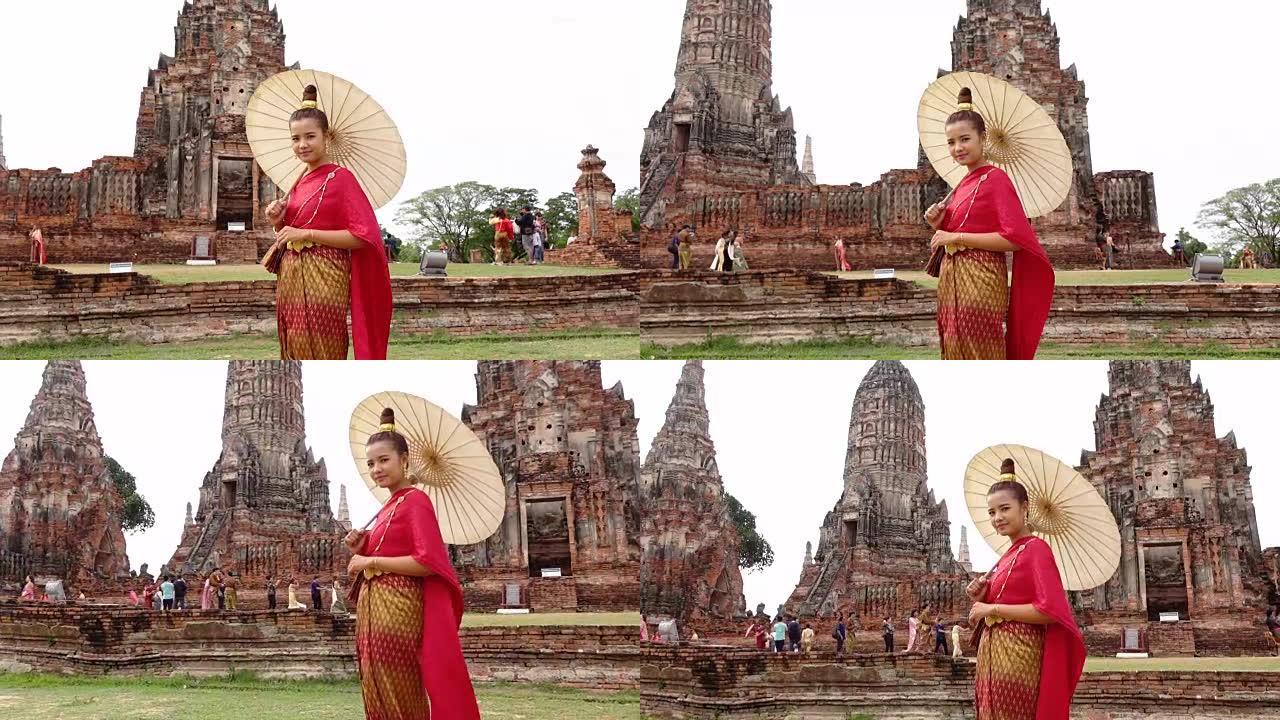 穿着泰国民族礼服的泰国年轻女子在阿育泰的老庙中行走
