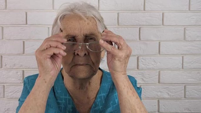 老妇人戴上眼镜，望着远方