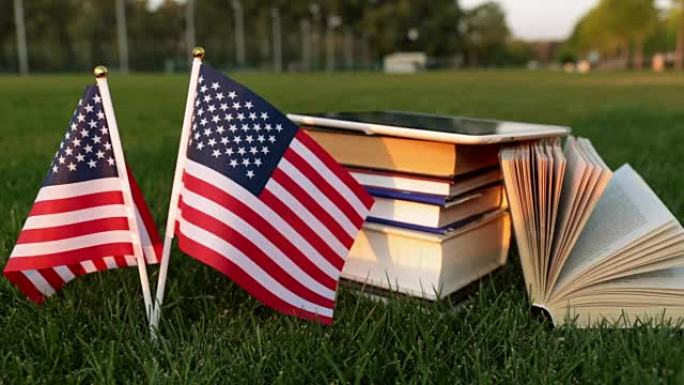 书和草地上的美国国旗。在美国学习。