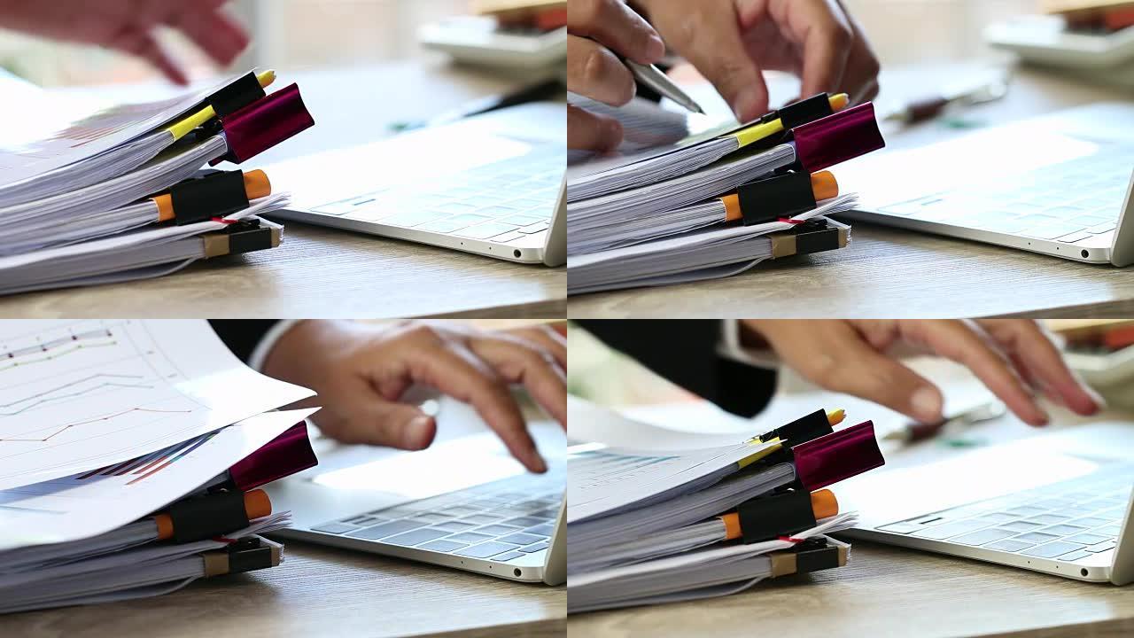 商人拿着笔在平板电脑上使用和搜索信息，在繁忙的工作过度办公桌上堆放未完成的文档纸质报告文件和笔记本电