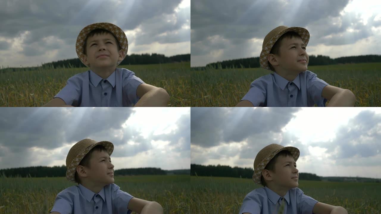 戴帽子的梦想家男孩看着美丽的天空