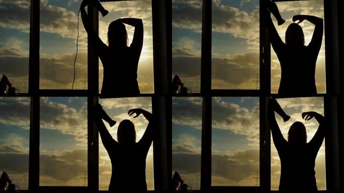 一名中年妇女在日落时吹干吹风机。