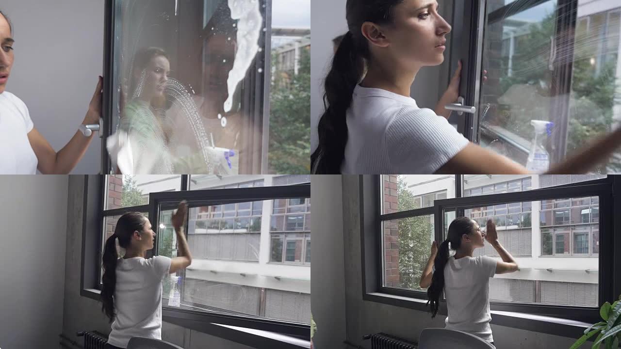 两名年轻妇女洗办公室窗户