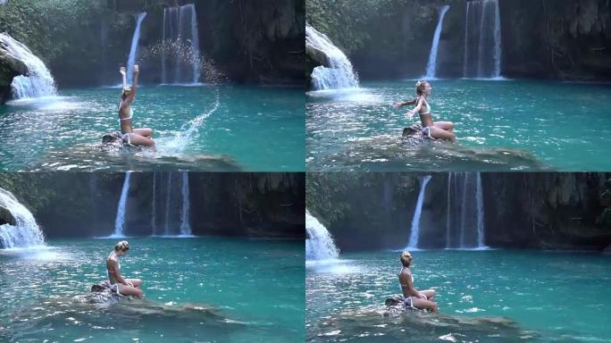 瀑布中的年轻女子玩水，慢动作视频。人们旅行乐趣享受理念。在菲律宾拍摄