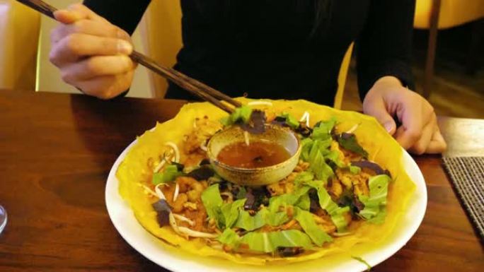 越南女孩的手在吃传统的越南菜