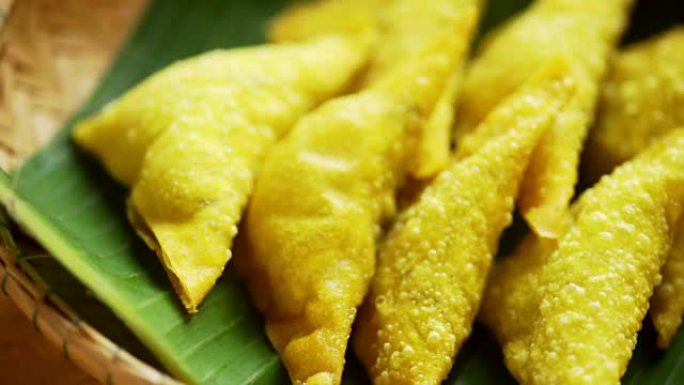 开胃菜煎饺子，放在传统的泰国北部美食脱粒篮中的香蕉叶上。