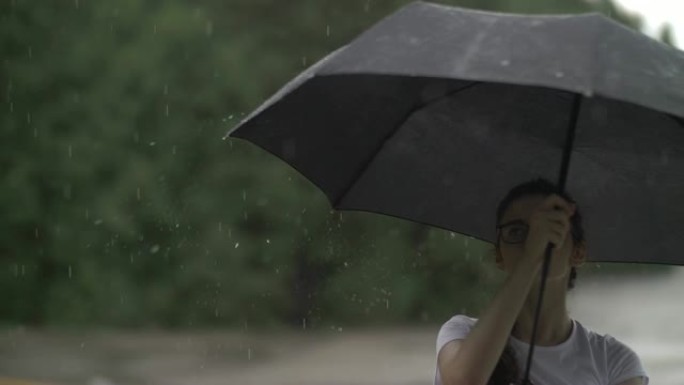 女孩在雨天旋转雨伞，看着雨滴打在雨伞上，秋天的心情，慢动作