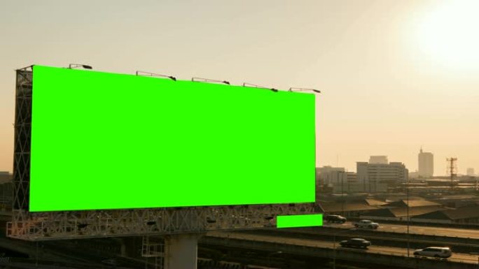 日落时分，泰国曼谷的城市背景下，高速公路上的广告广告牌绿屏。时间流逝。