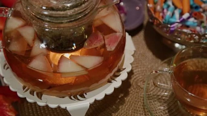 桌上摆着一个装有热茶的玻璃茶壶