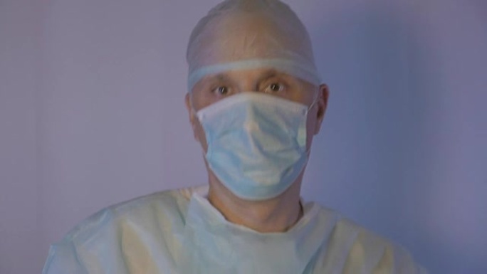 手术后，外科医生跳舞并摘下医用口罩。他很积极，很高兴一切都会好起来的。操作成功完成
