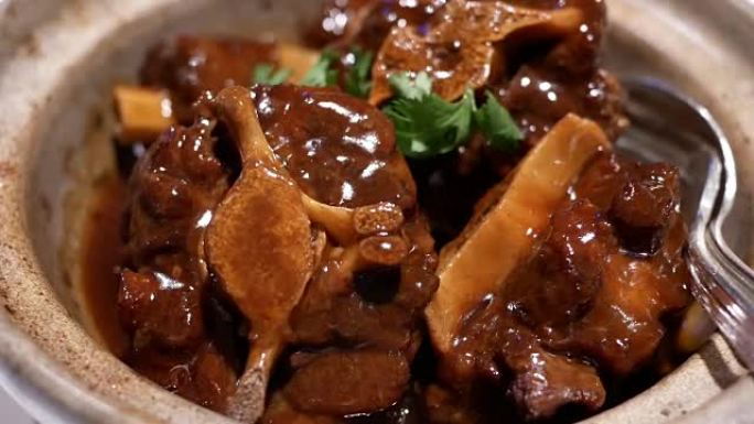 中餐馆小锅内炖牛尾和萝卜的运动
