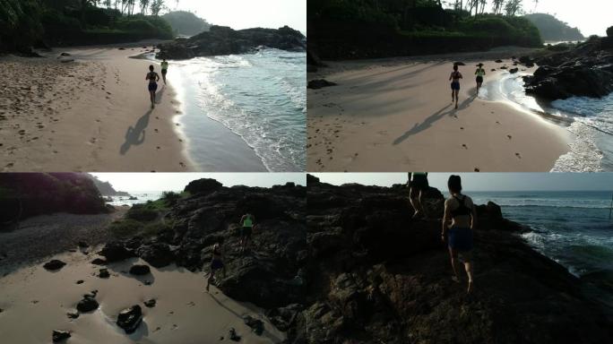 早上日出时，两个健康生活方式的年轻女性朋友在热带海滩上奔跑，航拍