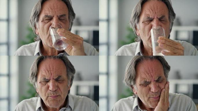 牙齿敏感的老人拿着一杯冷水