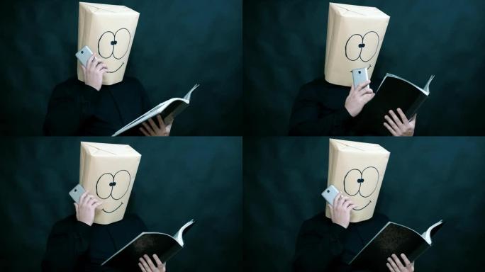 情感概念。一名男子正在笔记本上查看信息。在手机上收听消息。脸上是微笑和喜悦的表情。背景是黑暗模糊的。