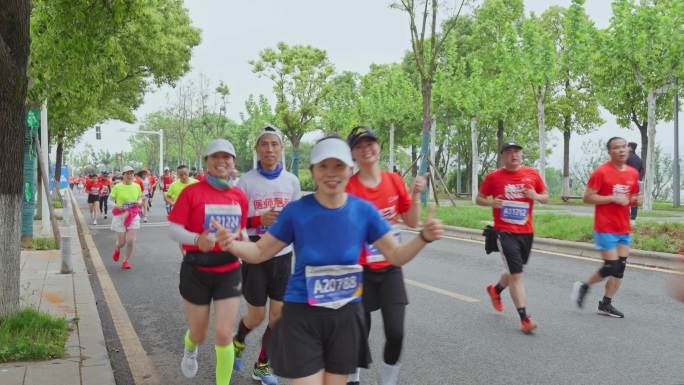 马拉松赛运动员跑步向镜头开心打招呼