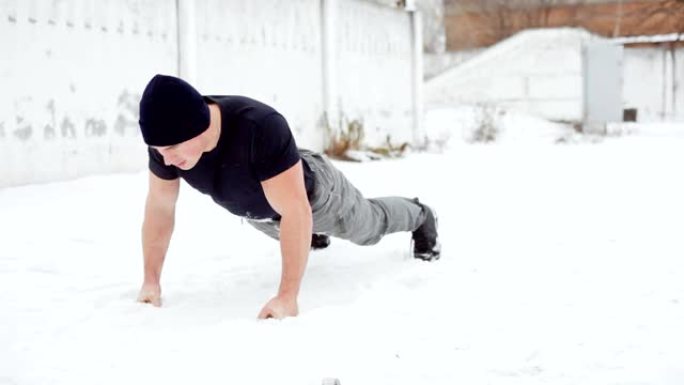 男子在下雪的冬天参加运动，俯卧撑