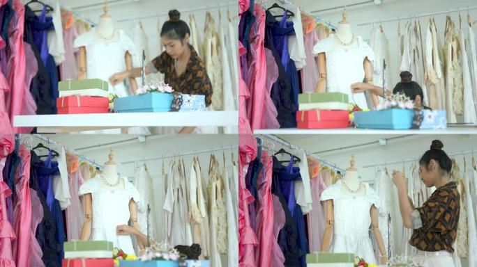 亚洲女性，制衣工人正在测量面料店缝制的衬衫的长度。
