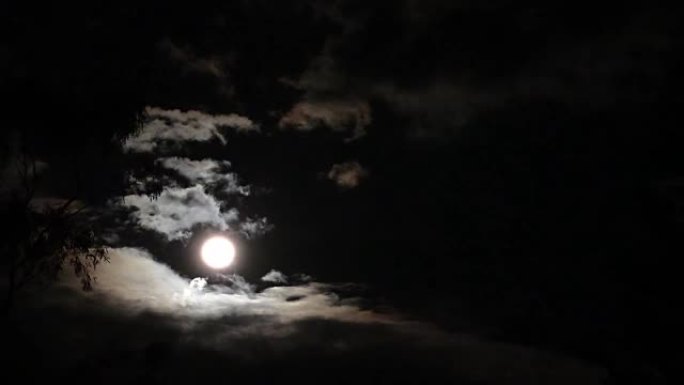 满月在多云的夜空上投射光
