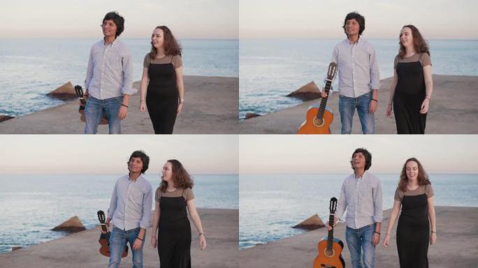 美丽的音乐家夫妇沿着海边的码头散步