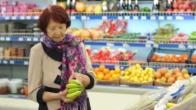 一位脸上有皱纹的老妇人在超市里选择产品。