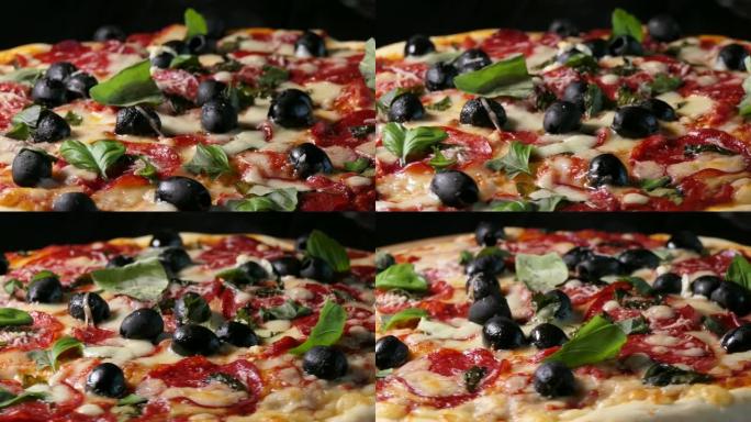 烤披萨配意大利香肠、黑橄榄、罗勒和莫扎雷拉奶酪。旋转镜头。