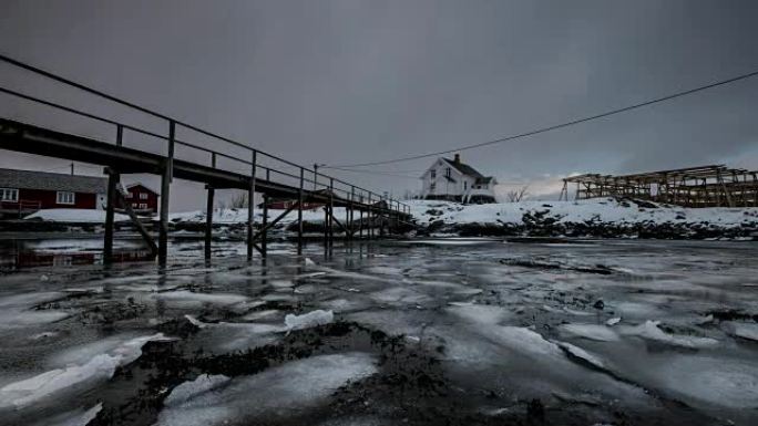 挪威罗弗滕群岛的暴风雪中的木屋在海岸线上漂浮的冰破裂的时间流逝