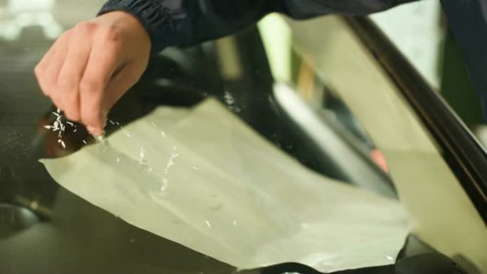 一个专业的人在车间从事消除汽车挡风玻璃上的裂缝的特写镜头。