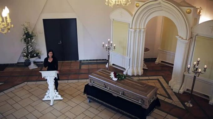 东正教教堂的葬礼上的悲伤的女人和棺材