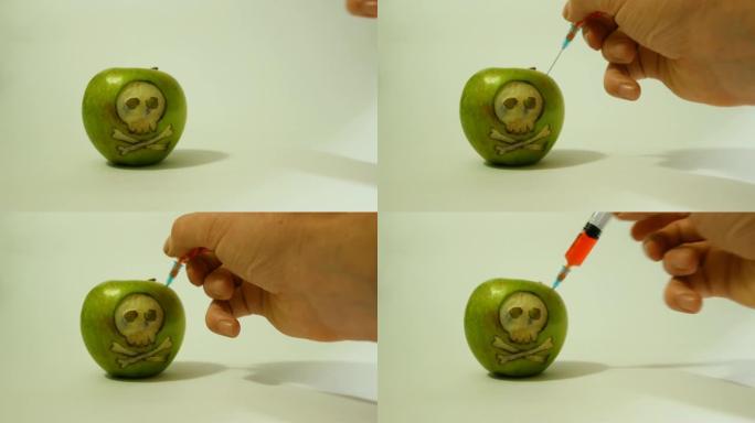 注射器插入带有雕刻头骨的青苹果中，代表食品，蔬菜和水果中使用转基因物质的形象