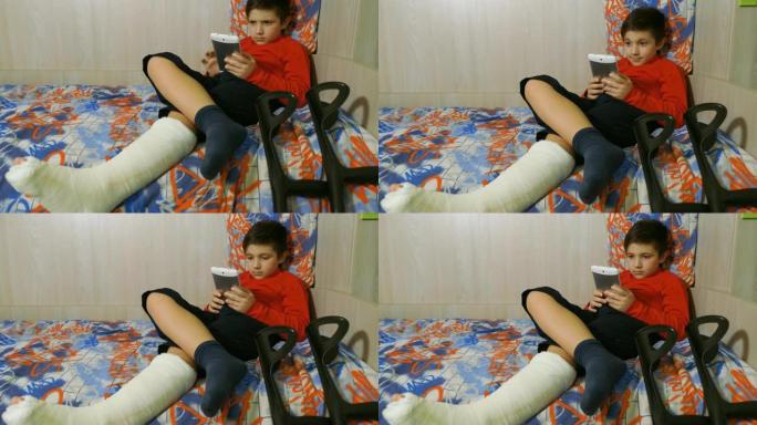 腿部骨折的微笑男孩玩智能手机 -- 室内