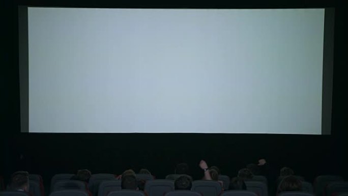 观众为在白色屏幕前观看电影而鼓掌