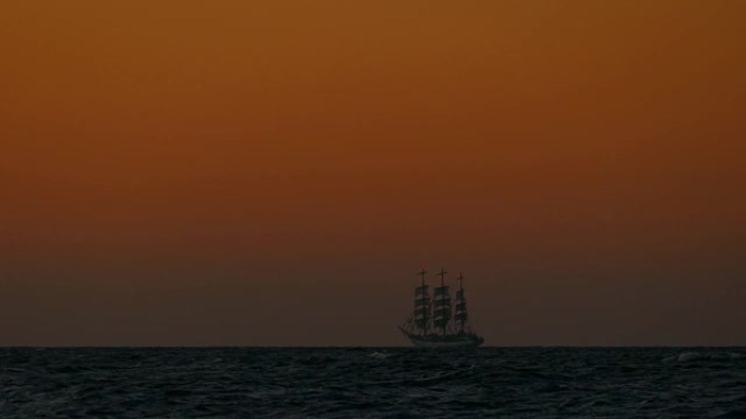 海中日落时高高的船的剪影