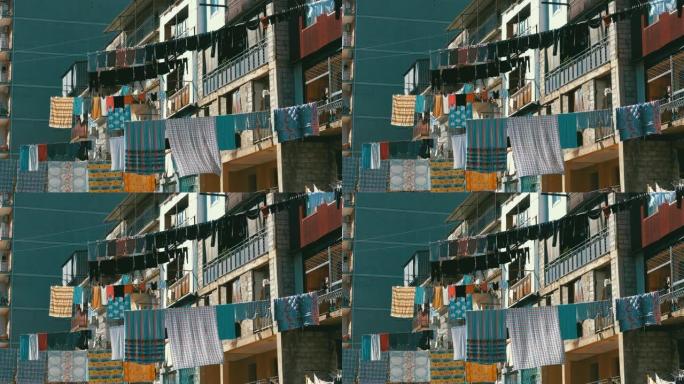 在城市贫困地区的一栋多层建筑物上的绳索上悬挂和干燥的衣服