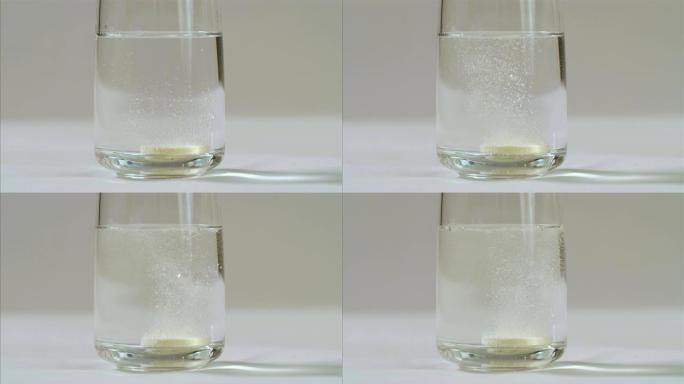 冒泡维生素c片剂在黑色背景上的一杯水中气泡，75 fps慢动作