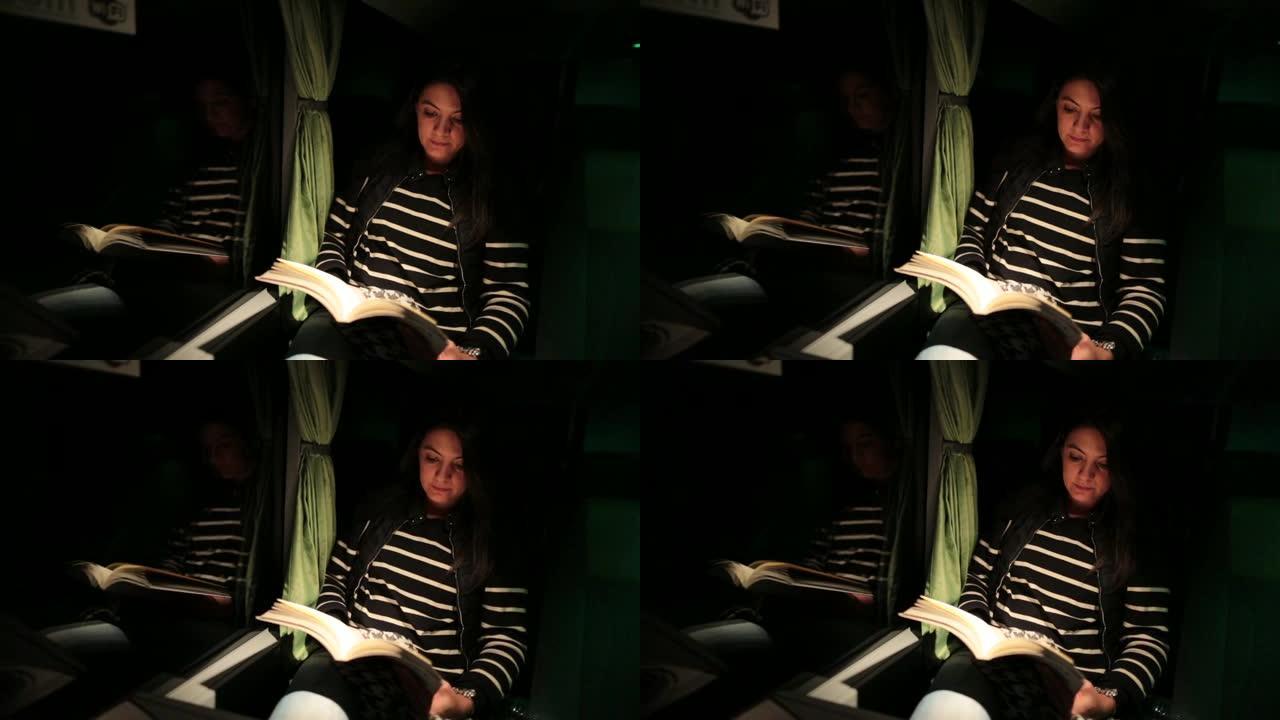 女人坐在公共汽车上过夜时看书