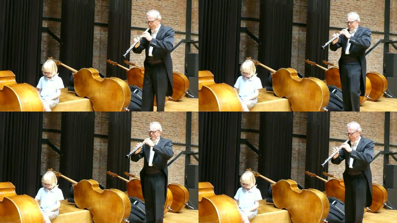 男音乐家正在和他的孙子玩双簧管和低音提琴。