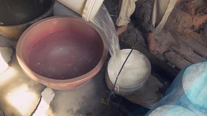 关闭一个男人用带孔的水桶中的水软化米粉