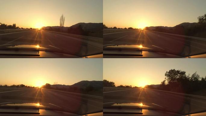 从车内可以看到高速公路上美丽的日落。旅游概念。