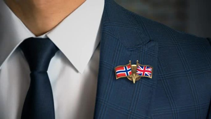 商人走向相机，带着朋友国家的国旗别针挪威-英国